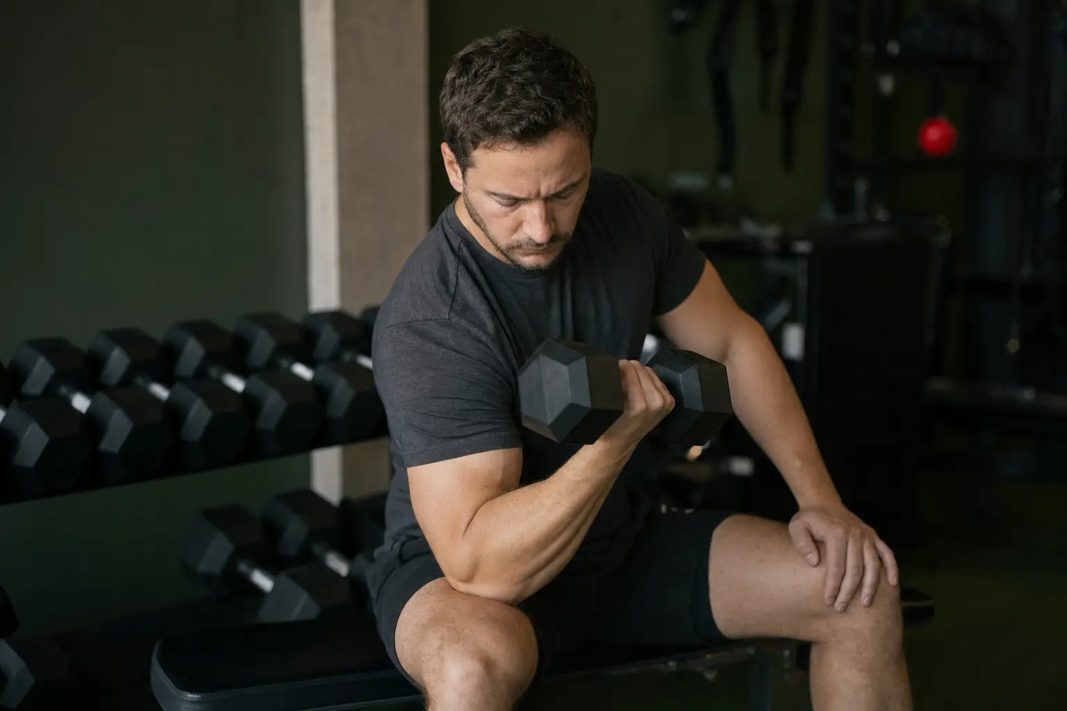 A man doing dumbbell curls in a gym.