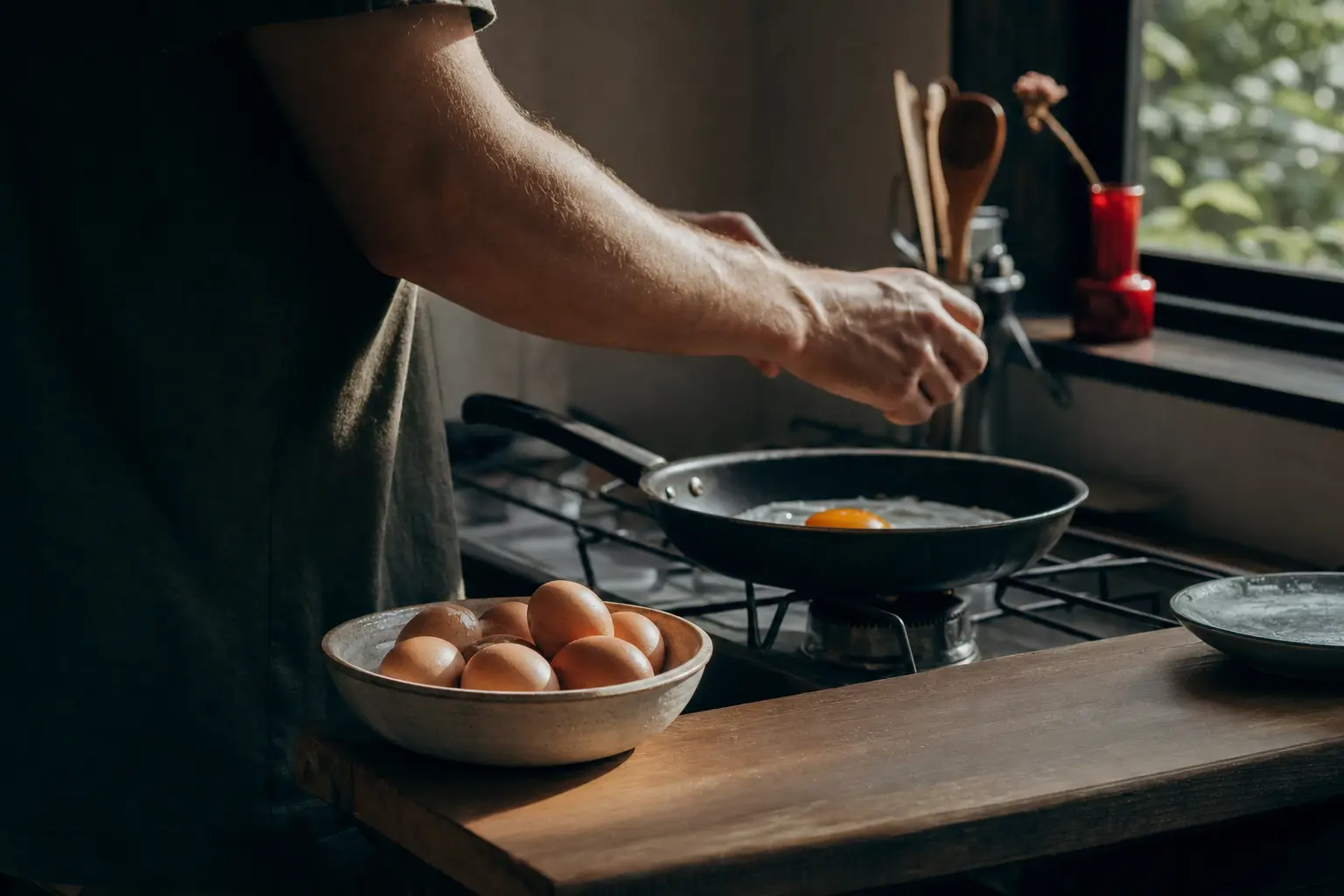Eggs in a bowl on a kitchen counter, one cracked into a pan.